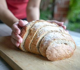 Hand holding slices of sourdough bread on wooden board
