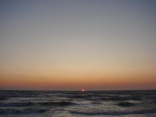 Incredible natural picture of a colorful sky over the stormy blue infinity of the Azov Sea at dawn.