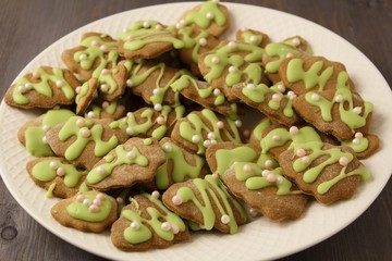 Christmas ginger cookies coated with green festive glaze on a white plate