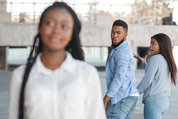 Guy turning and looking to another woman while walking with girlfriend - obrazy, fototapety, plakaty