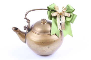 Ancient teapot with ribbon on white background