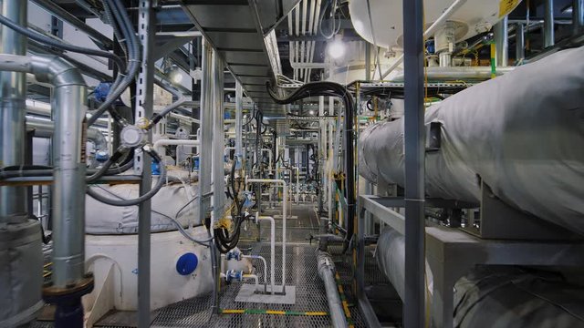 Chemical plant inside. Modern equipment, steel tanks and boilers with cables, pipelines and valves for chemical mixing. Production of anti-turbulent additives used in the oil industry.