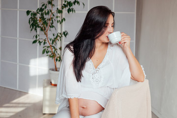 Portrait of a pregnant woman drinks preparation for childbirth