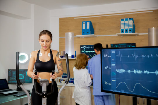Female athlete who makes a physical effort on the stepper and has electrodes and heartbeats attached to it.