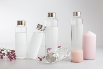 Clear glass water bottles on a bright grey background