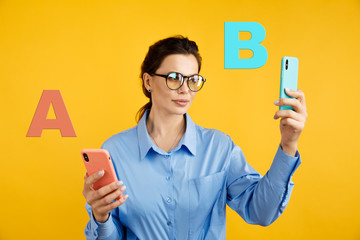 conversion funnel, A B test in marketing and online advertising. Brunette woman holding colored letters A and B in hands with face expression.