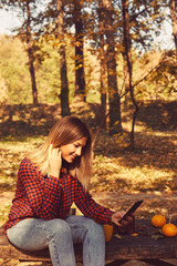 Attractive woman talking on her cellphone and enjoying in autumn day.