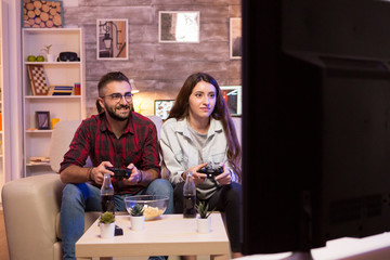 Relaxed couple playing video games on television