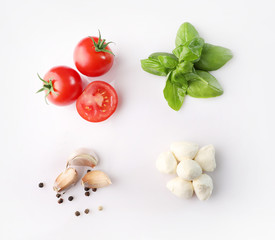 Set of ripe red cherry tomatos and mozzarella and spices on white background. Top view