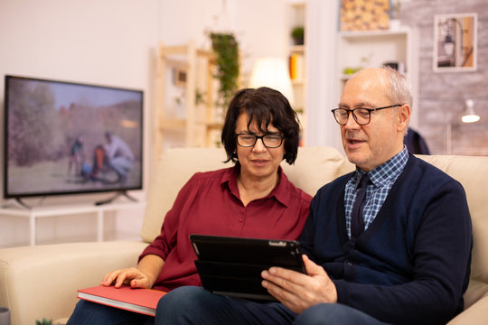 Beautiful old couple using a digital tablet to chat with their family