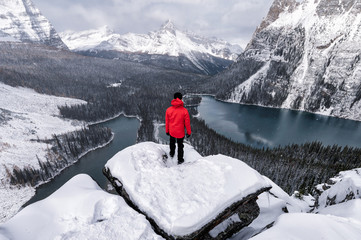 Traveler standing on rock over Opabin Plateau with lake O'hara in snowing at Yoho national park