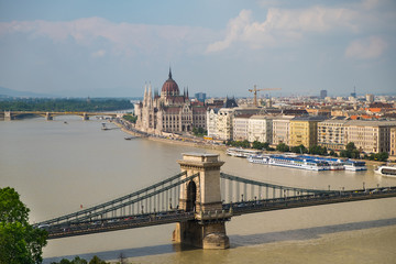 Fototapeta na wymiar View of historical building of Hungarian Parliament and chain bridge on Danube river in Budapest, Hungary, Europe.