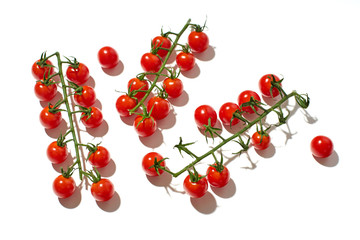 Naklejka na ściany i meble Healthy colorful cherry tomatoes on white background in hard sun light with harsh shadows. Vegan meal. Pattern isolated
