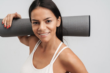 Image of woman in sportswear holding fitness mat while doing workout