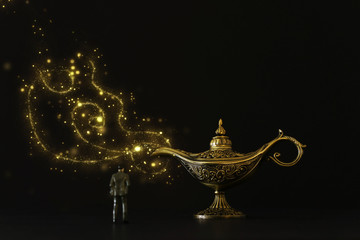 Concept picture of a businessman looking at Aladdin lamp with smoke, asking for a wish