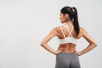 Obraz premium Image of woman in sportswear standing from back with arms on waist