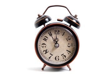 Old, retro alarm clock on white background, isolate. It was twelve o'clock.