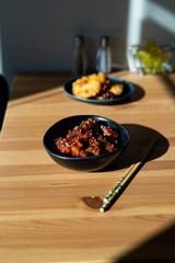 Asian Food Homemade Chinese General Tsos Chicken with Sesame Seeds served with Chopsticks.