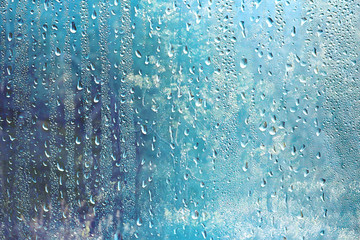 summer rain wet glass / abstract background landscape on a rainy day outside the window blurred background