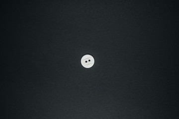 White button on dark background close up