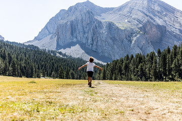 Little boy running throw a big meadow