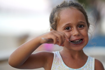 4 year old girl eating and smiling.