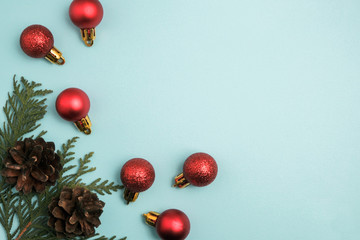Christmas winter composition. Red balls with pine cones on blue background. Top view, flat lay
