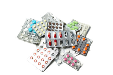 A pile of pills in blister packs. Blister packs full of multi-colored pills isolated on a white background.  Lot of tablets.