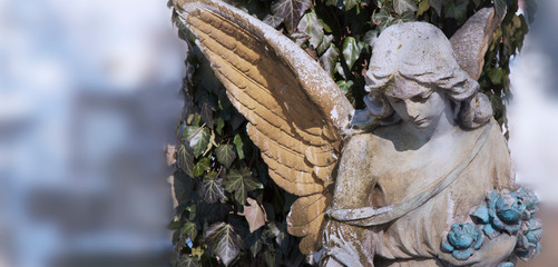 Vintage image of a beautiful angel against the background of winter background. Antique statue.