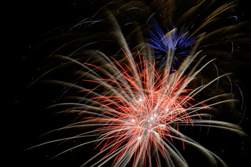 Colorful fireworks that explode and fill the darkness of the night sky with colored light.