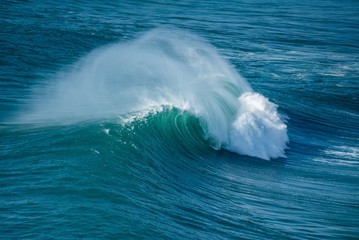 Surfers sailing in the Atlantic Ocean near the Nazare municipality in Portugal