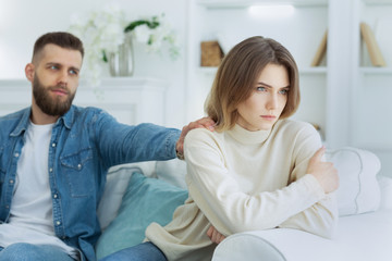 Fototapeta premium Loving man soothing upset woman, apologizing after quarrel