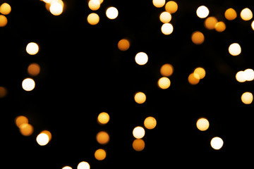 Abstract background with golden glitter light bokeh isolated on black background. It can be used as overlay design.