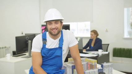 Smiling builder looks and nods his head at the camera