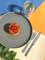 Strawberry creamy dessert in a serving with green tea on a colorful background