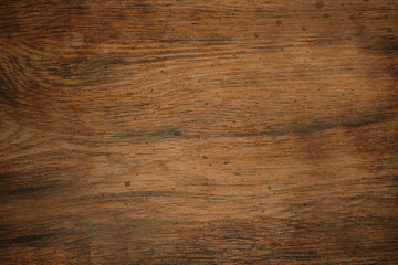 The wooden Board is brown with a rough texture and spots on the surface