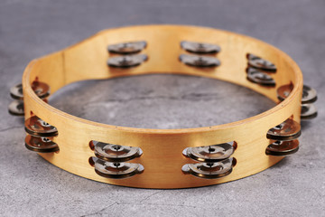 Tambourine percussion music instrument with small metal jingles called 'Zills' on gray background
