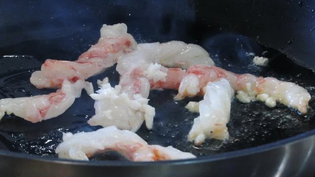 The langoustes are fried in a frying pan in the kitchen