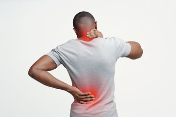 Black guy rubbing his painful neck and back