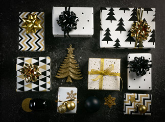 Fototapeta na wymiar Christmas concept - black and golden presents and decorations, marble background, top view