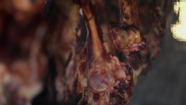 Ham and bacon hanging and drying in smokehouse on traditional way on blue smoke.  The sunrays pierce through the blue smoke.