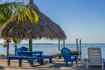 Beach chairs and tiki hut on the shore at King's Kamp, Key Largo, Florida