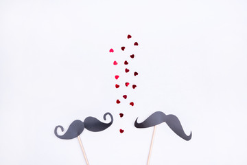 Beautiful toppings with a man's moustache on a gray background with hearts. The concept of homosexual relations