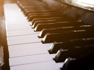 Old retro piano keys. close up view. Black and white keys, octave. Lighting effect