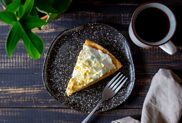 Lemon pie with meringue on a wooden background.