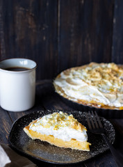 Lemon pie with meringue on a wooden background.
