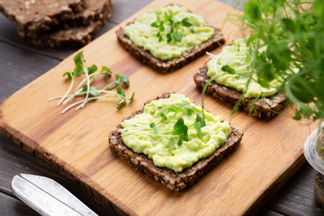 Wholegrain sandwiches with avocado spread and microgreens