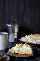 Lemon pie with meringue on a wooden background.