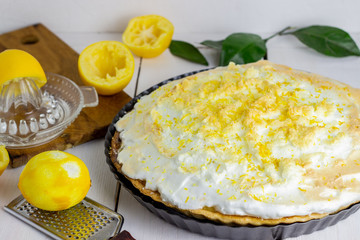 Lemon pie with meringue on a wooden background.