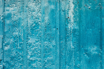 The old surface is painted with blue oil paint. Close-up. Texture. Abstract background